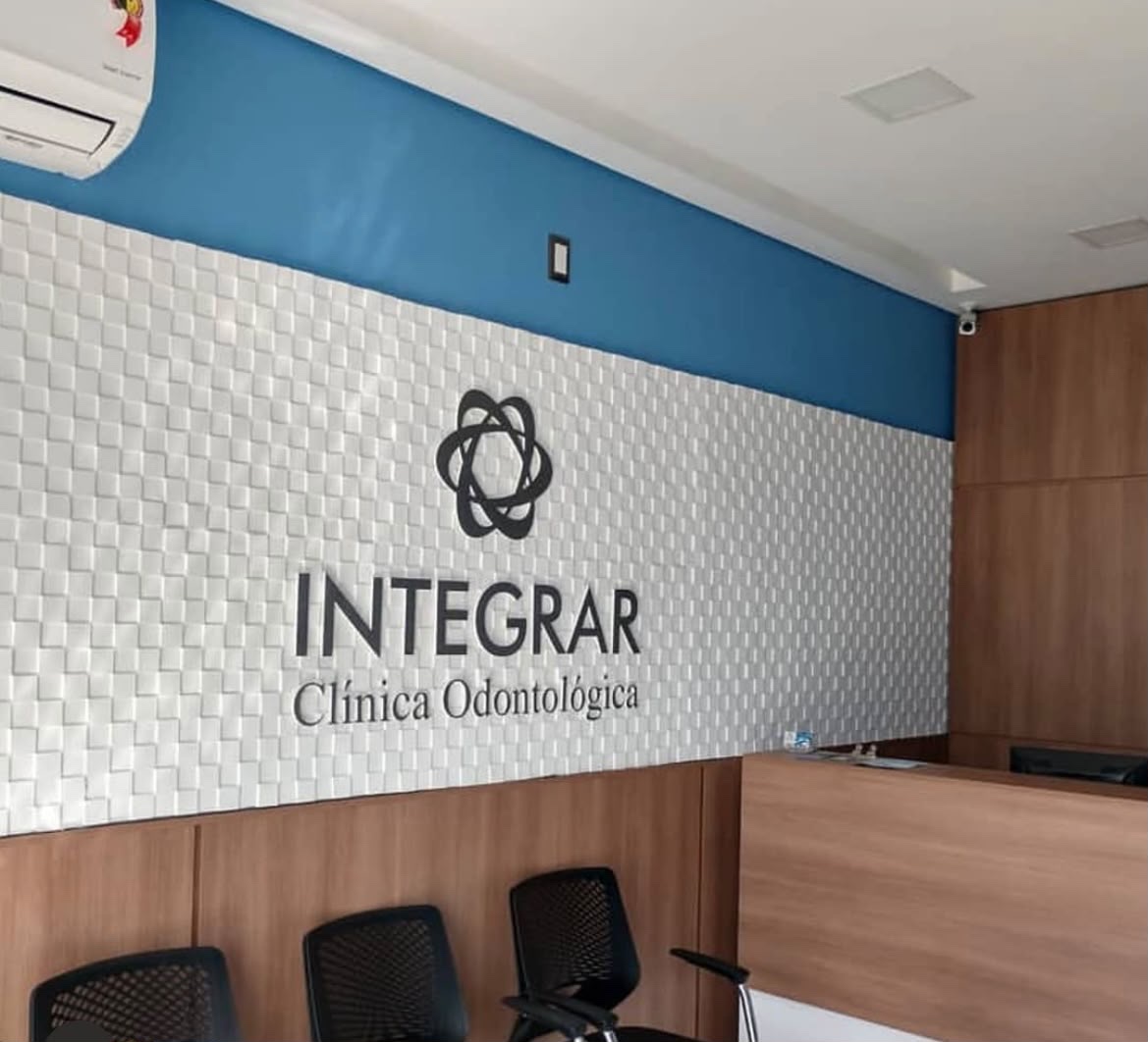 Parede com o logo da Integrar Clínica Odontológica na recepção